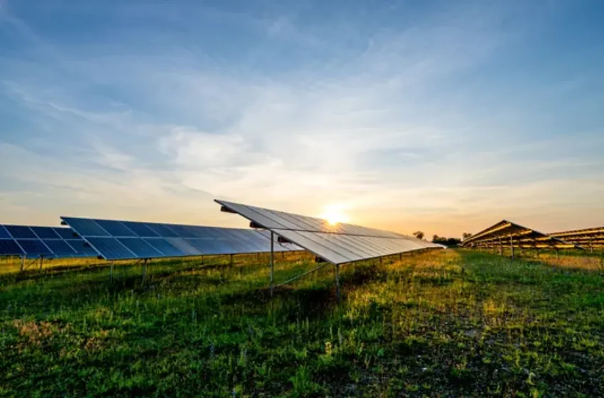Solar field at sunset beside a facility